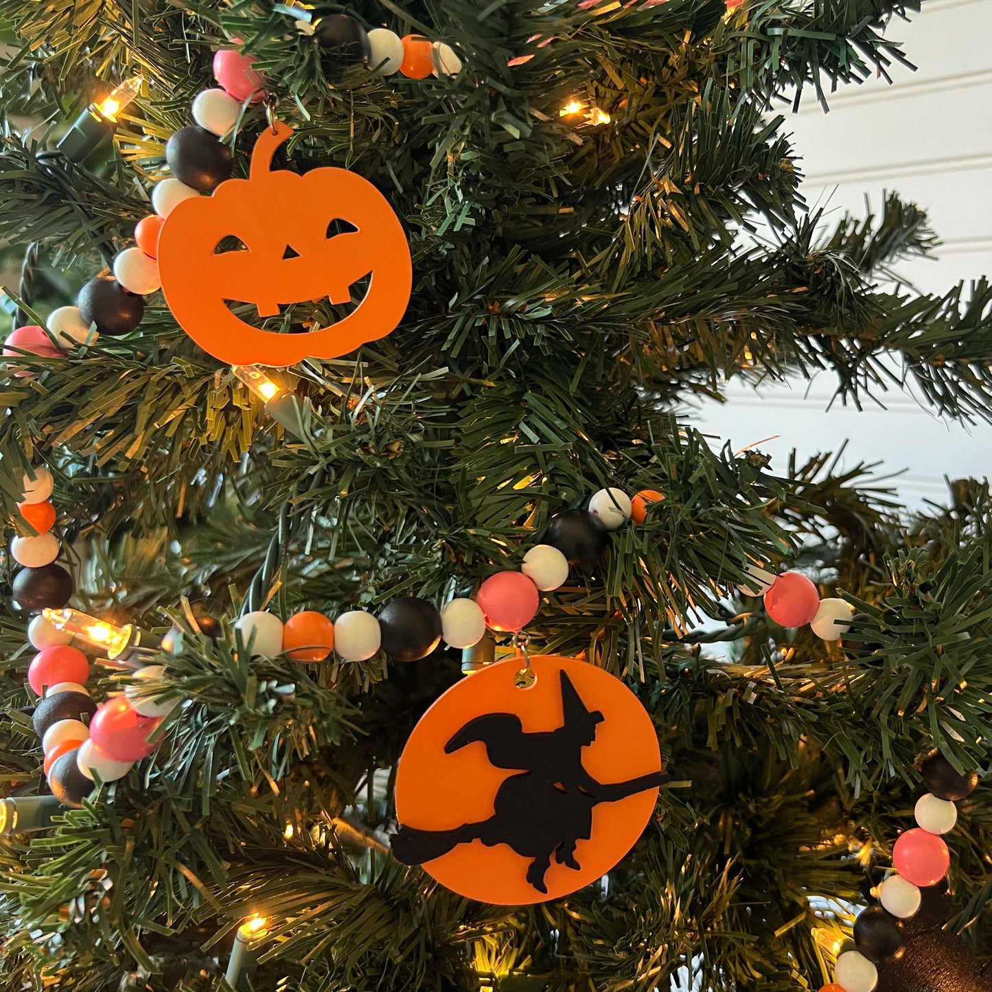 A Bewitching Halloween Handmade Garland. The garland features a witch on a broom, two black cats, and two jack-o-lanterns. Halloween, autumn, fall theme decoration or gift.