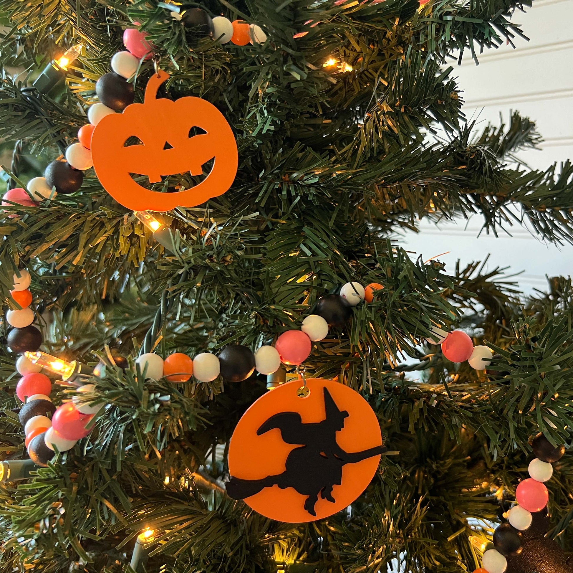 A Bewitching Halloween Handmade Garland. The garland features a witch on a broom, two black cats, and two jack-o-lanterns. Halloween, autumn, fall theme decoration or gift.