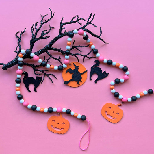 A Bewitching Halloween Handmade Garland. The garland features a witch on a broom, two black cats, and two jack-o-lanterns. Halloween, autumn, fall theme decoration or gift.