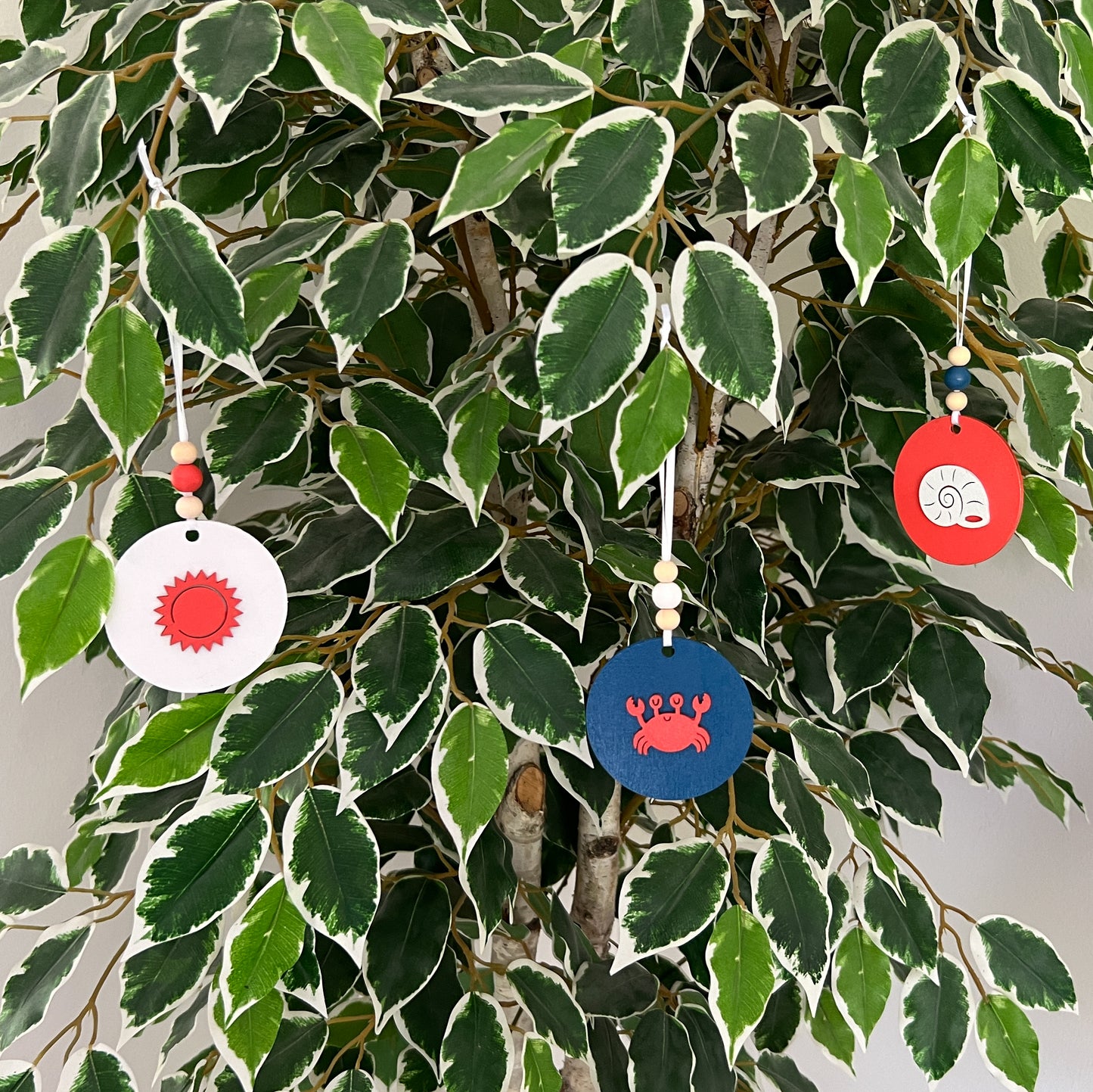 At the Seashore Beachy Set. Three wood ornaments featuring a shell, the sun, or a crab. Summer decor, year-round holiday tree ornament, or gift.
