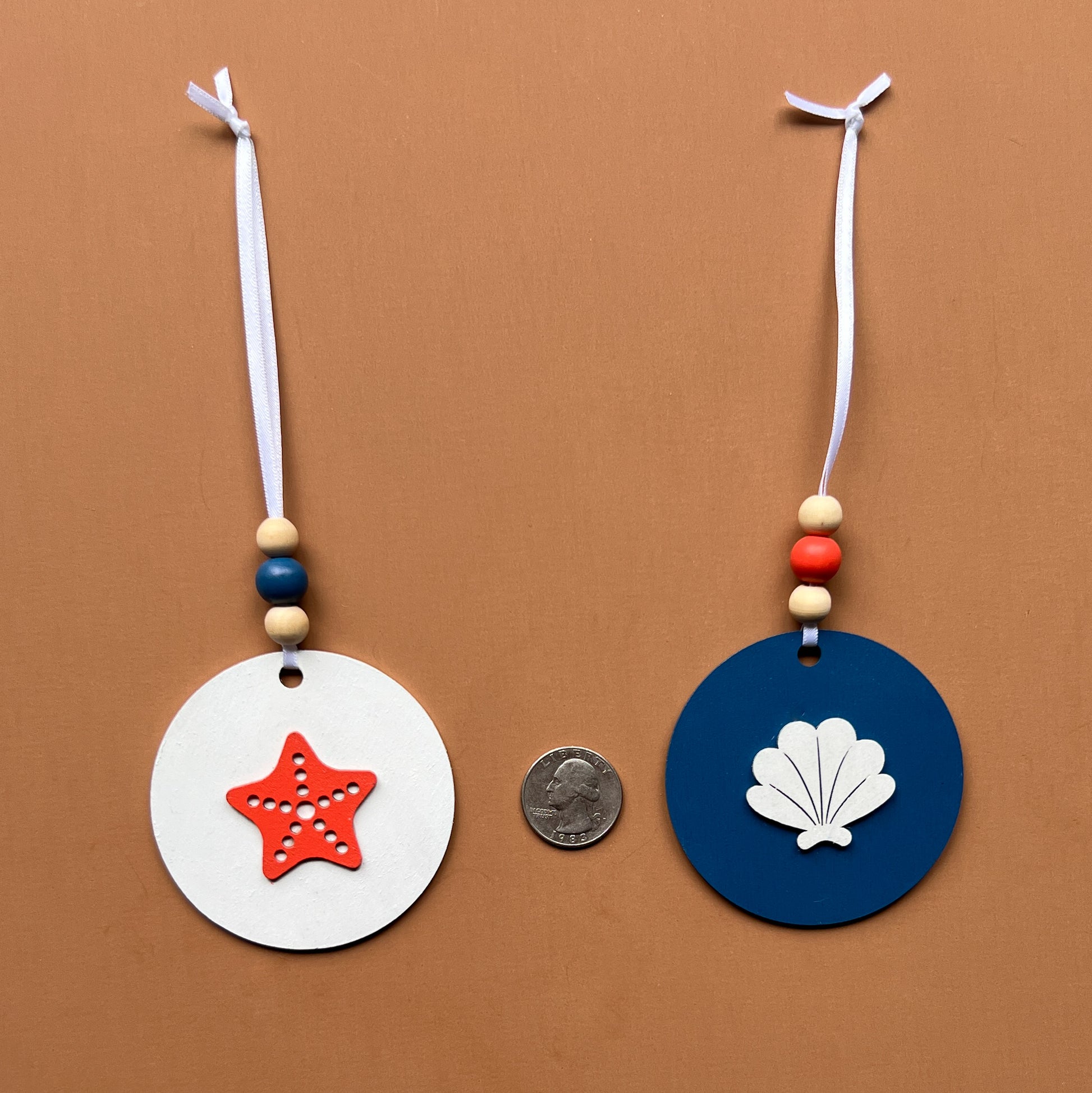 At the Seashore Beachy Set. Three wood ornaments featuring a shell, a seahorse, or a starfish. Summer decor, year-round holiday tree ornament, or gift.