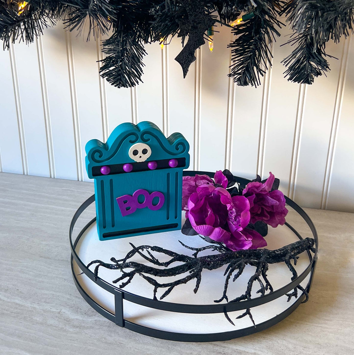 Bright Boo Tombstone Shelf Sitter. Features vibrant colors of blue and purple with a ‘boo’ wood cutout and a little skull. It's free standing, but has a keyhole cutout on the back so can hang on the wall. Halloween decor.