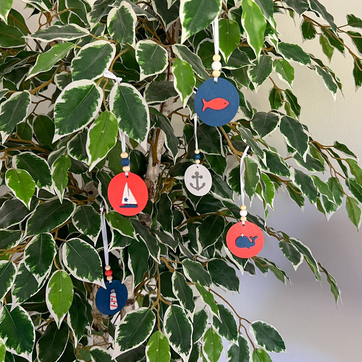 Calm Little Seas Handmade Ornament Set of 5. Ornaments feature ocean themed shapes – a fish, a sailboat, a ship anchor, a lighthouse, and a whale. Summer seasonal decor; year-round tree ornaments or gifts.
