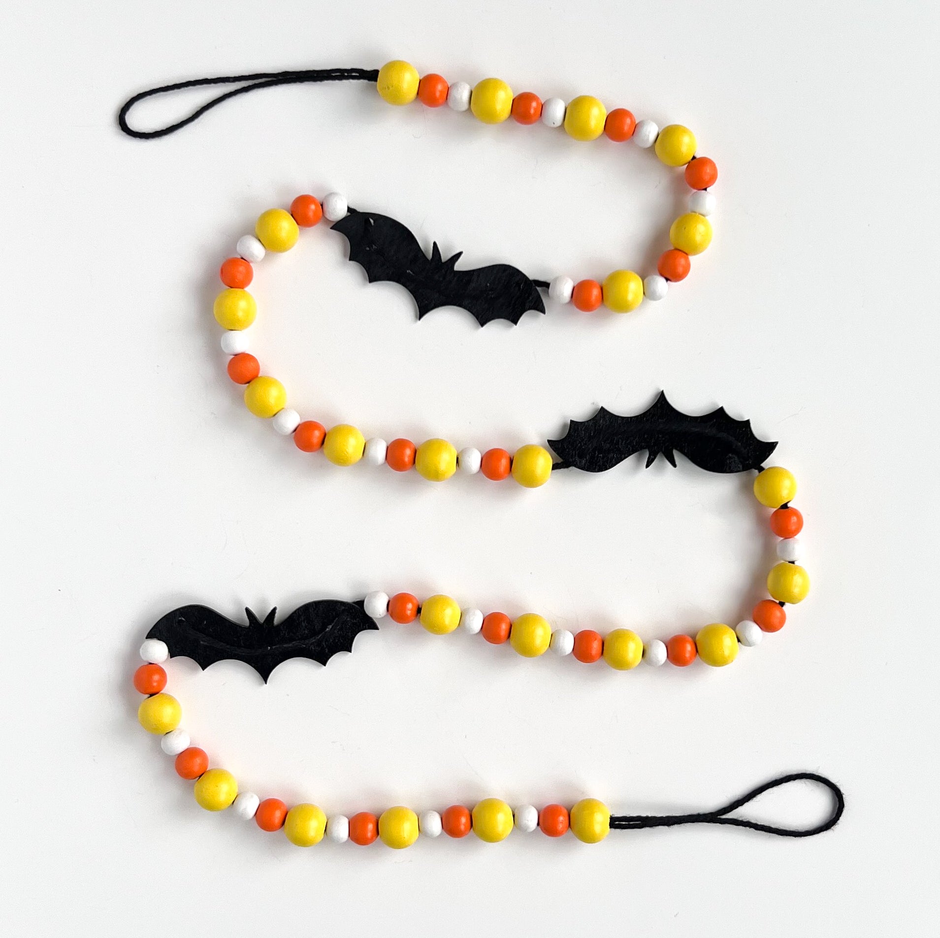 Candy Bats Handmade Garland. The garland features three black bats strung with wood beads in candy corn colors. Halloween, autumn, fall theme decoration or gift.
