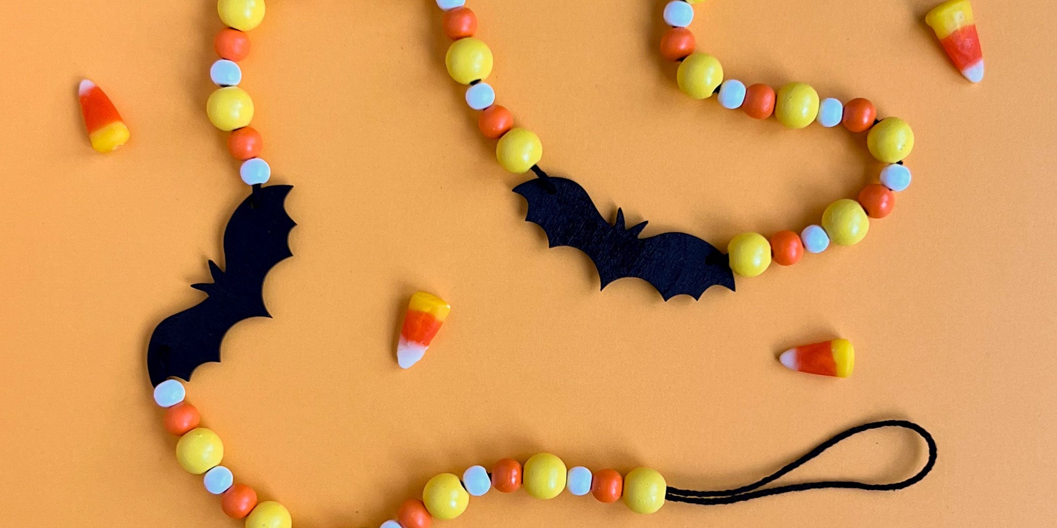 Candy Bats Handmade Garland. The garland features three black bats strung with wood beads in candy corn colors. Halloween, autumn, fall theme decoration or gift.