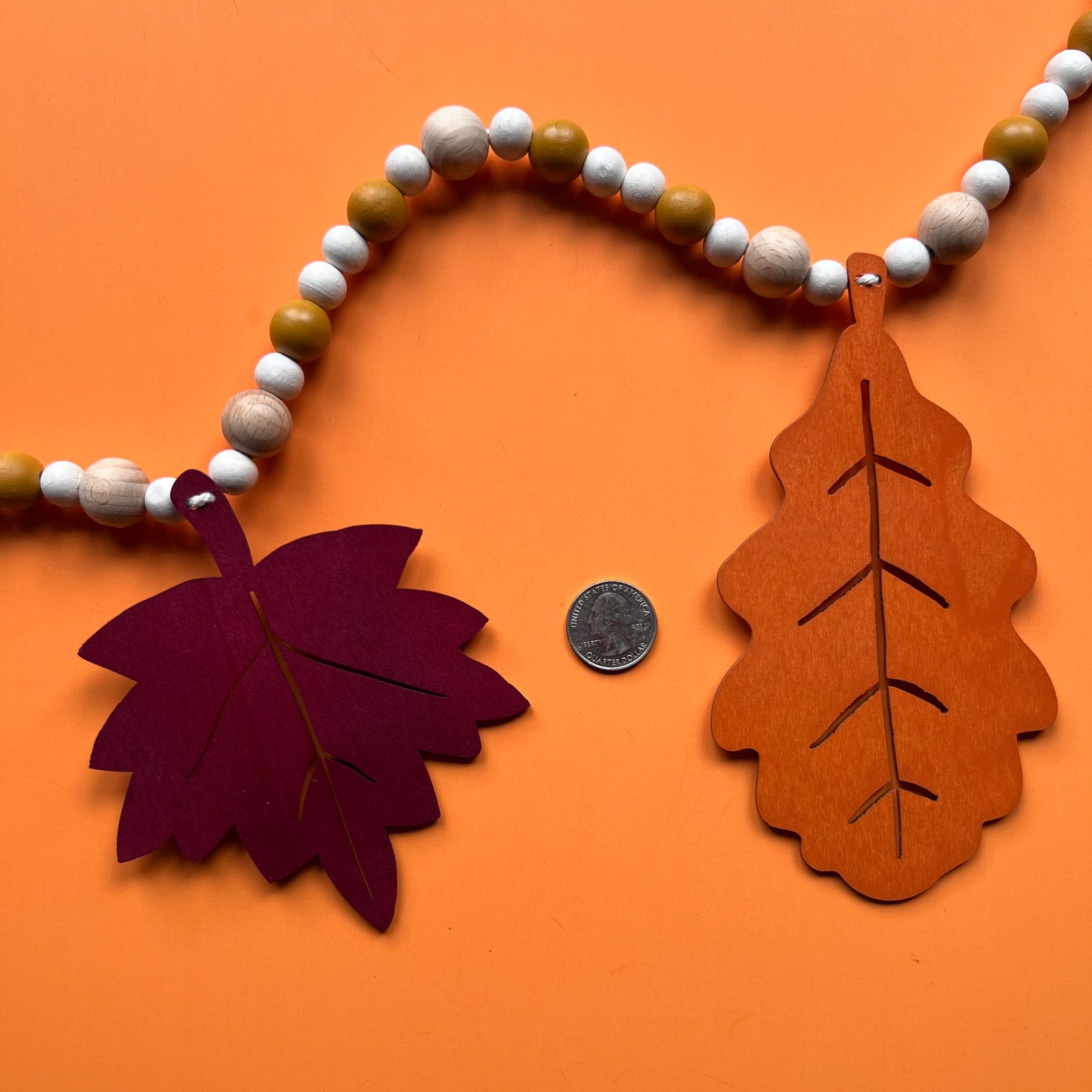 Fall themed wood bead garland with two wood oak leaves and three maple leaves strung with beads.