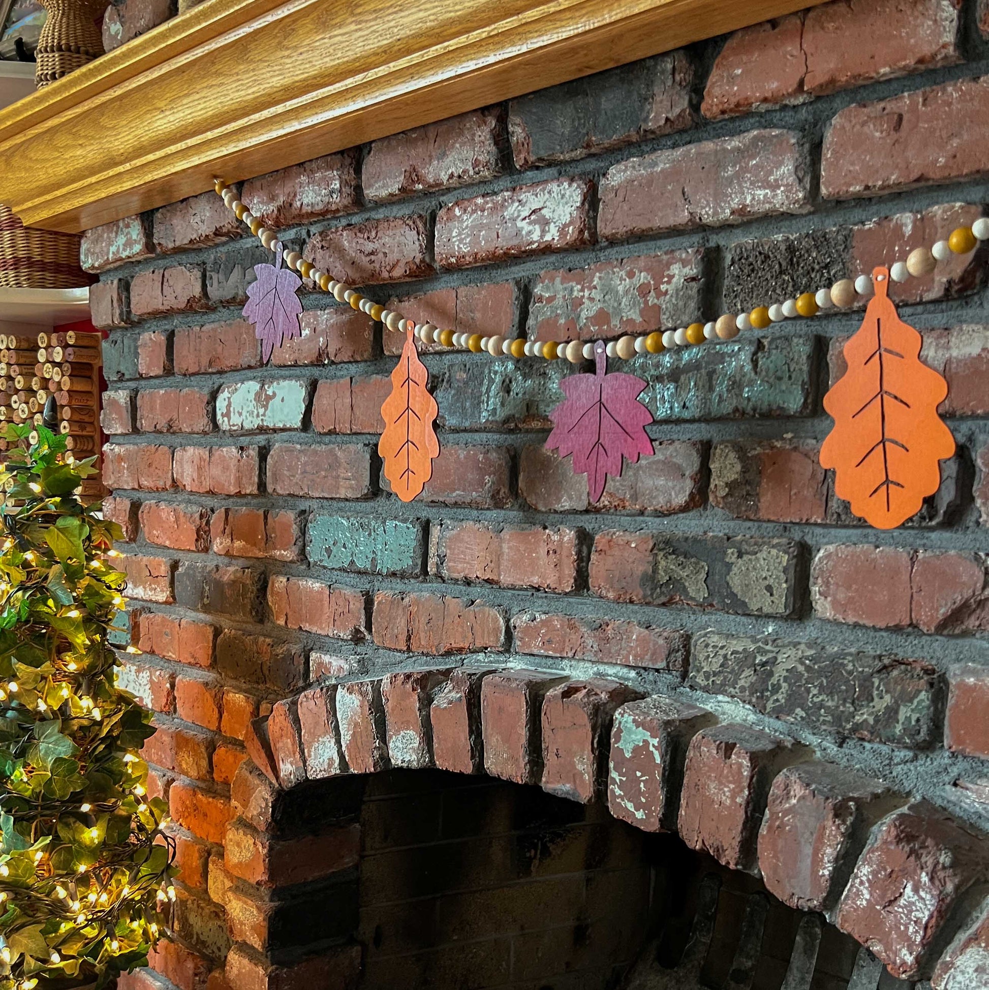 Fall themed wood bead garland with two wood oak leaves and three maple leaves strung with beads.