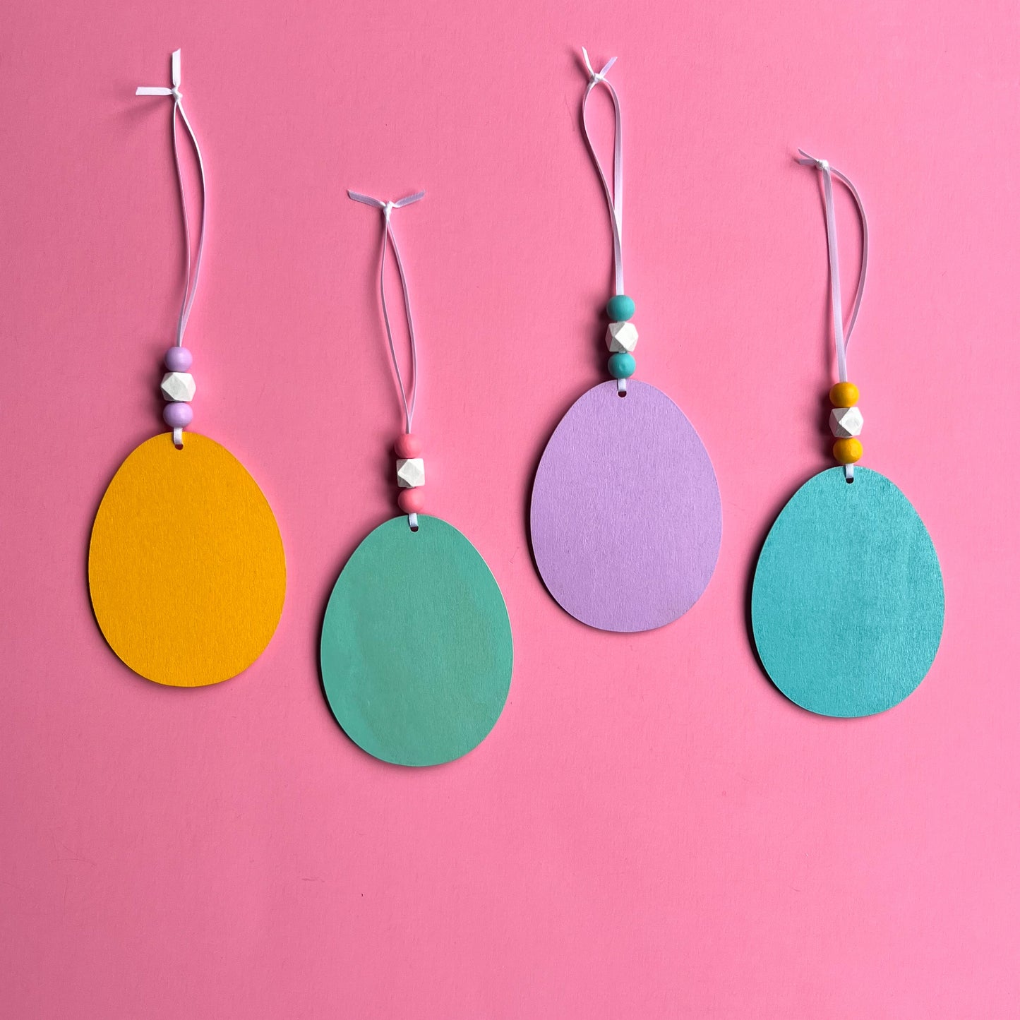 Hello Spring Handmade Ornaments. Flat egg shape ornaments with spring and Easter themed shapes - carrots, flower, rabbit paws. Spring decoration or gift.