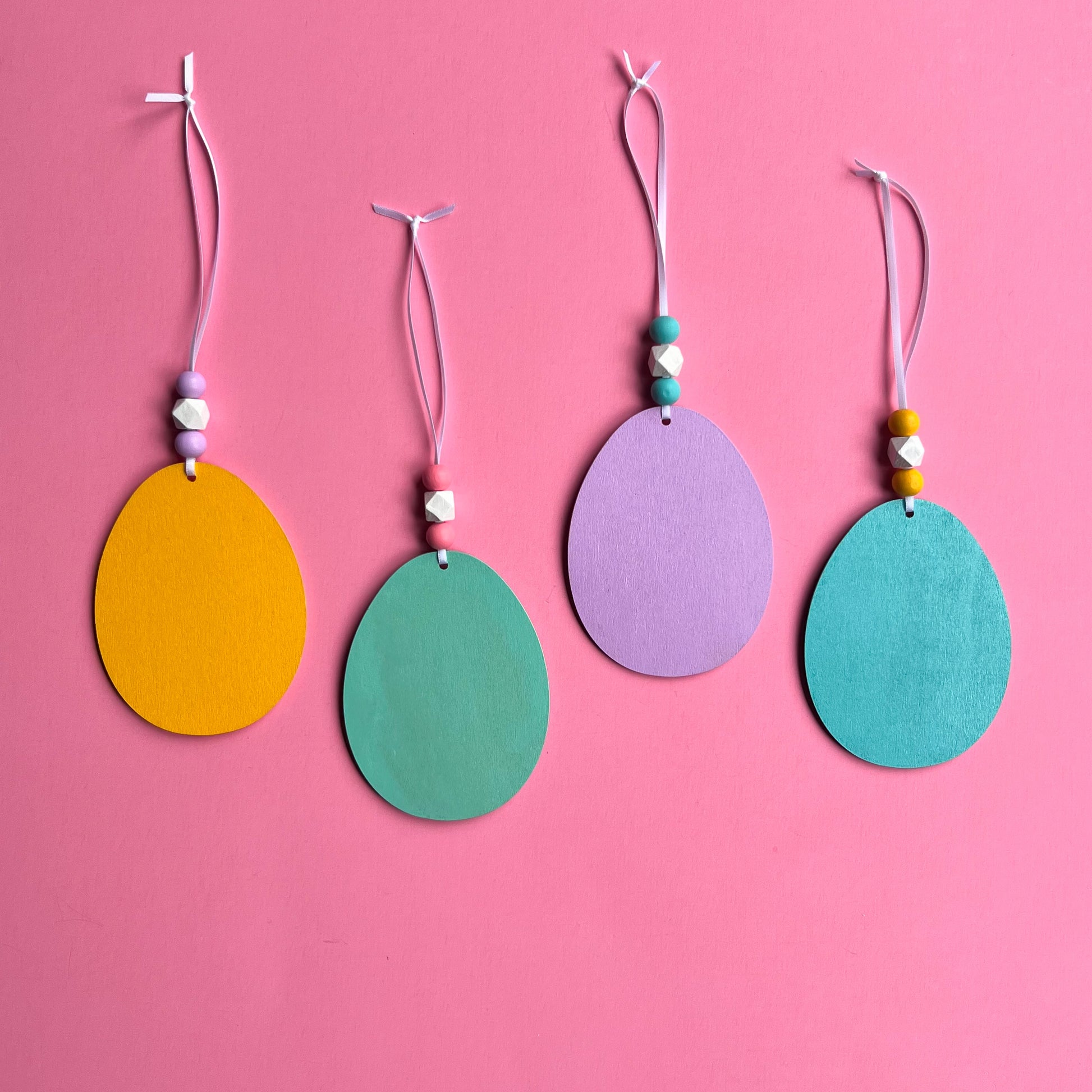 Hello Spring Handmade Ornaments. Flat egg shape ornaments with spring and Easter themed shapes - carrots, flower, rabbit paws. Spring decoration or gift.
