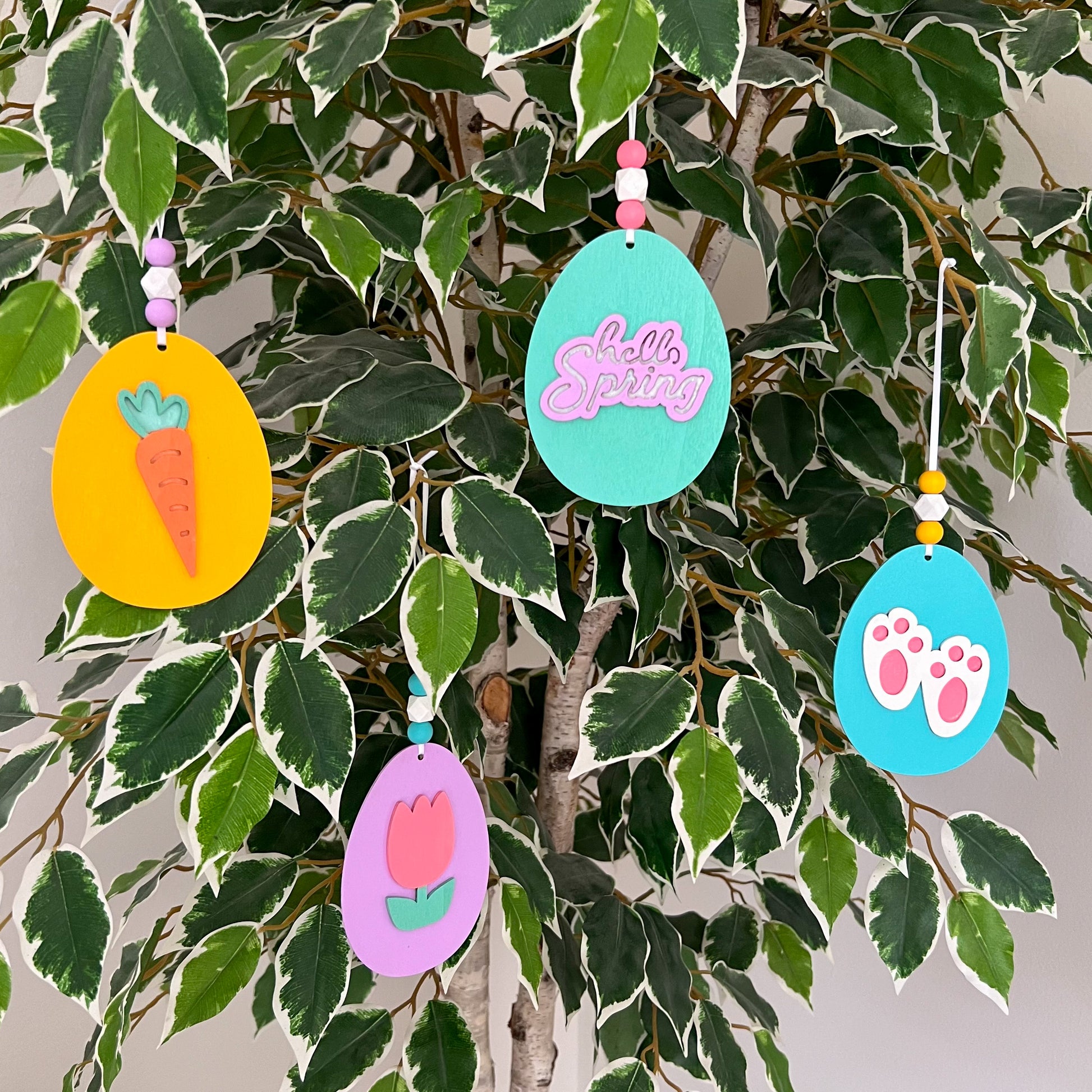Hello Spring Handmade Ornaments. Flat egg shape ornaments with spring and Easter themed shapes - carrots, flower, rabbit paws. Spring decoration or gift.
