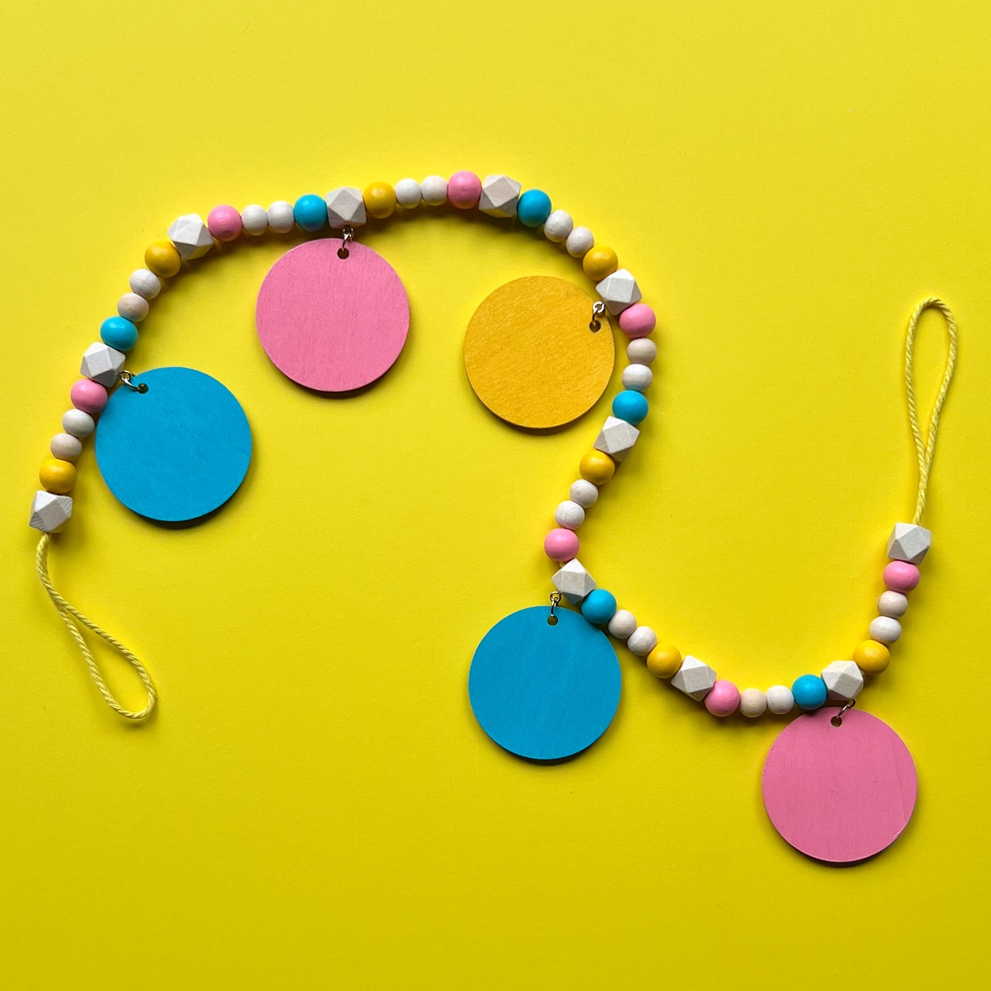 Tropical Little Vacay Mini Garland. Features wood shapes of a pineapple, flamingo, leaf, drink, and flower. Wood bead garland for summer, tropical theme decor or gift.