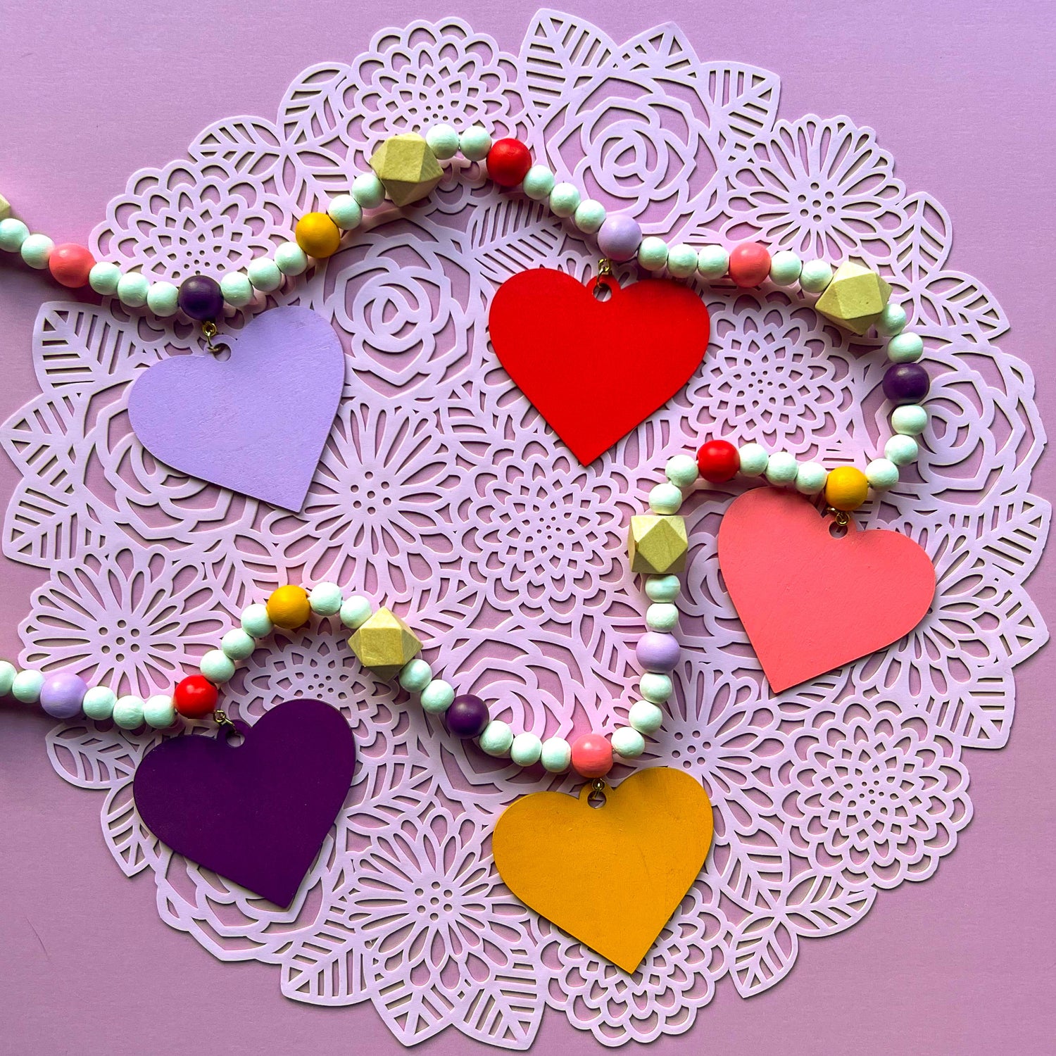 Bright Hearts Handmade Garland. Features wood heart shapes. Valentine's Day decor or gifts.