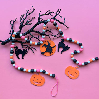 A Bewitching Halloween Handmade Garland. The garland features a witch on a broom, two black cats, and two jack-o-lanterns. Halloween, autumn, fall theme decoration or gift.