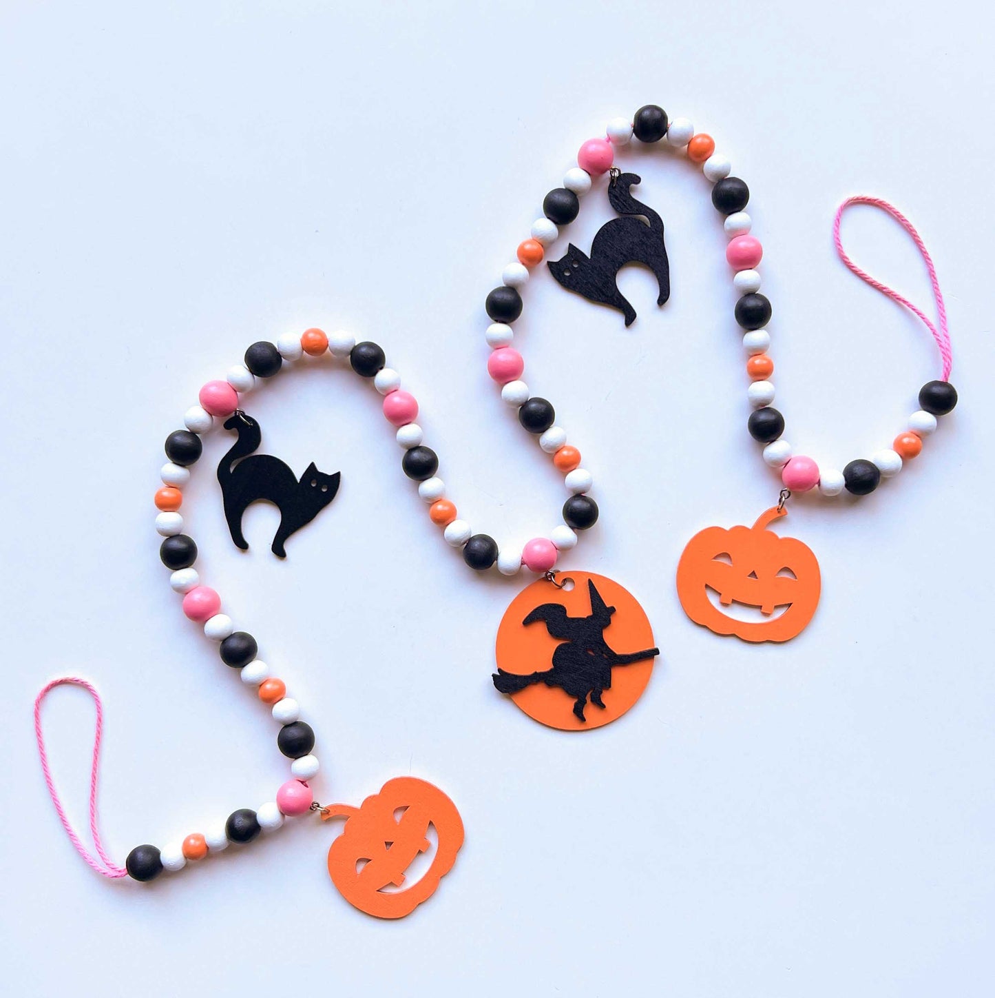 A Bewitching Halloween Handmade Garland. The garland features a witch on a broom, two black cats, and two jack-o-lanterns. Halloween, autumn, fall theme decoration or gift.