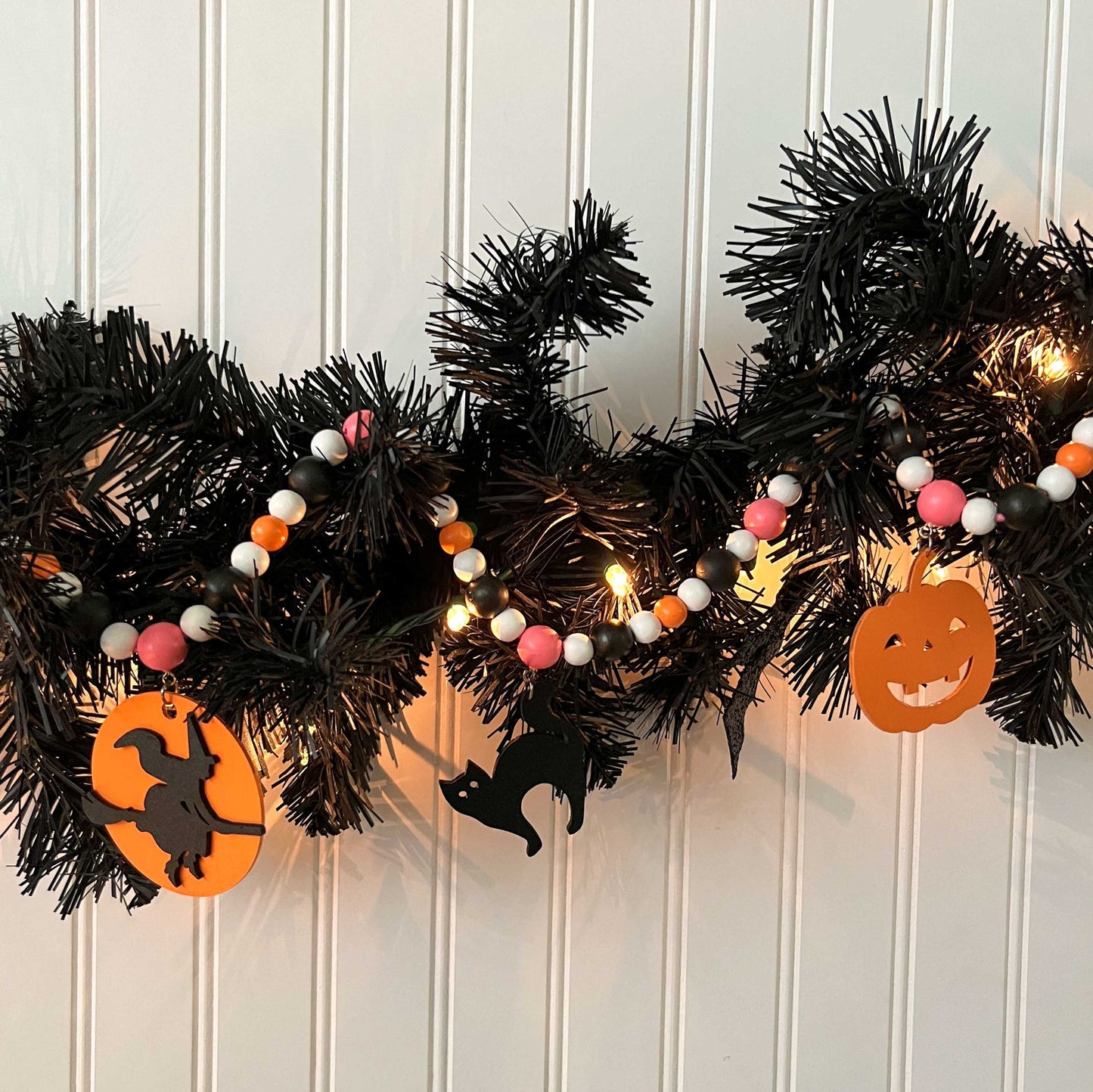 A Bewitching Halloween Handmade Garland. The garland features a witch on a broom, two black cats, and two jack-o-lanterns. Halloween, autumn, fall theme decoration or gift.
