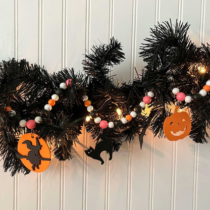 A Bewitching Halloween Handmade Garland. The garland features a witch on a broom, two black cats, and two jack-o-lanterns. Halloween, autumn, fall theme decoration or gift.