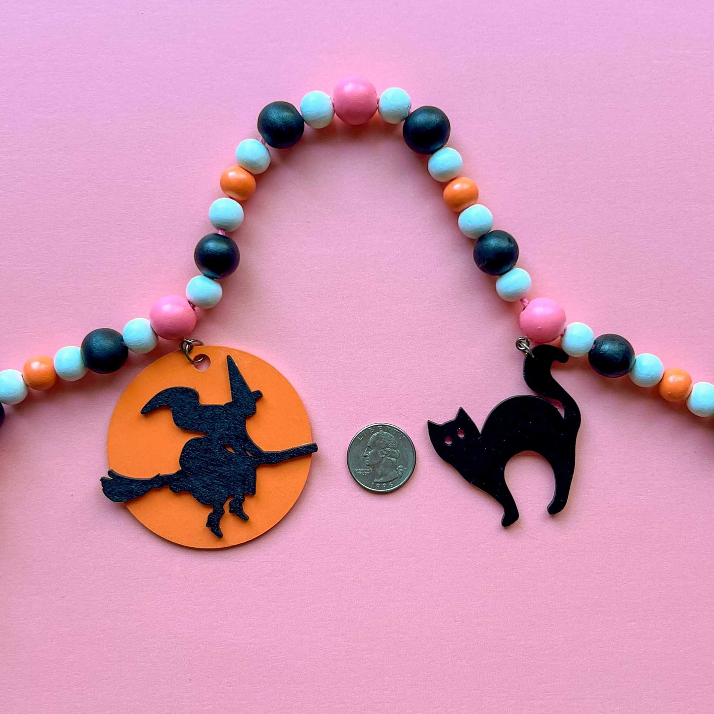 A Bewitching Halloween Handmade Garland. The garland features a witch on a broom, two black cats, and two jack-o-lanterns. Halloween, autumn, fall theme decoration or gift.