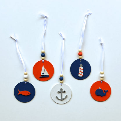 Calm Little Seas Handmade Ornament Set of 5. Ornaments feature ocean themed shapes – a fish, a sailboat, a ship anchor, a lighthouse, and a whale.  Summer seasonal decor; year-round tree ornaments or gifts.