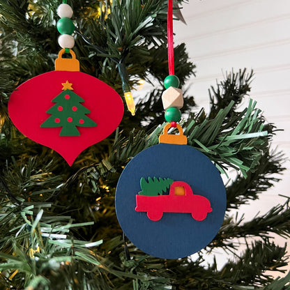 Image shows set of 3 flat wood handmade ornaments. Each ornament features a holiday themed wood shape: a decorated Christmas tree, a red stocking, or a truck bringing home the tree. Ornaments hang from ribbon and are decorated with three wood beads in matching colors.