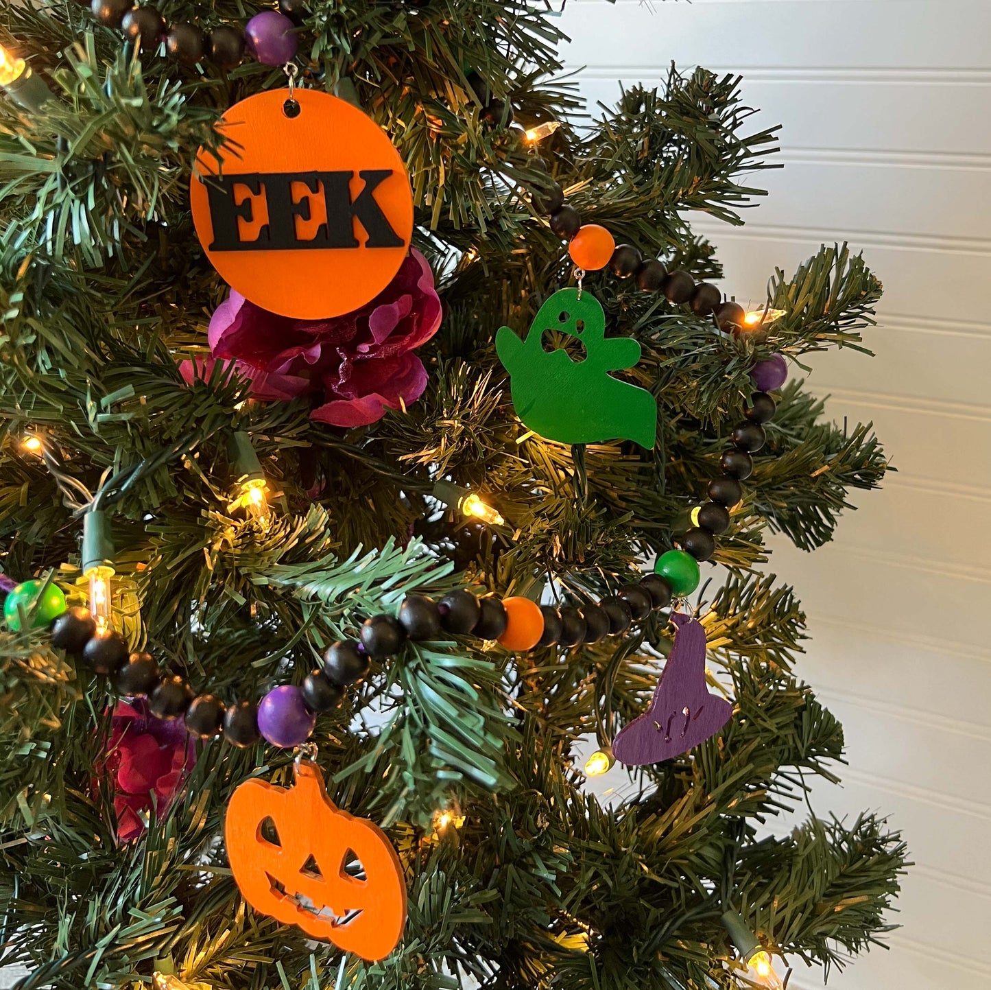 Eek! It’s Halloween Handmade Garland. The garland features seven Halloween themed shapes - pumpkins, ghosts, and witches’ hats. Shapes hang from painted wood beads. Halloween fall seasonal decoration or gift.