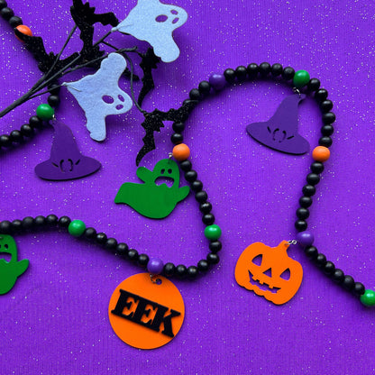 Eek! It’s Halloween Handmade Garland. The garland features seven Halloween themed shapes - pumpkins, ghosts, and witches’ hats. Shapes hang from painted wood beads. Halloween fall seasonal decoration or gift.