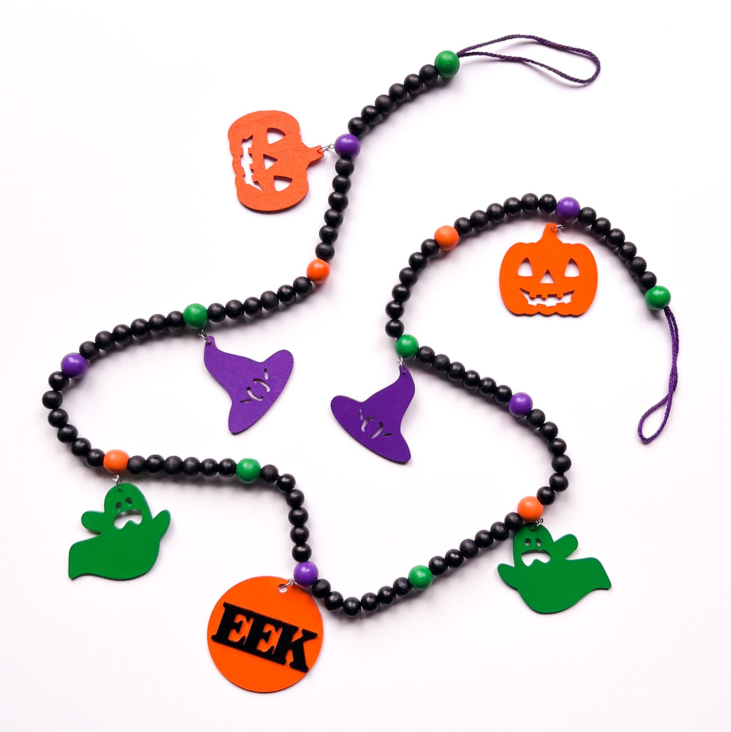 Eek! It’s Halloween Handmade Garland. The garland features seven Halloween themed shapes - pumpkins, ghosts, and witches’ hats. Shapes hang from painted wood beads. Halloween fall seasonal decoration or gift.