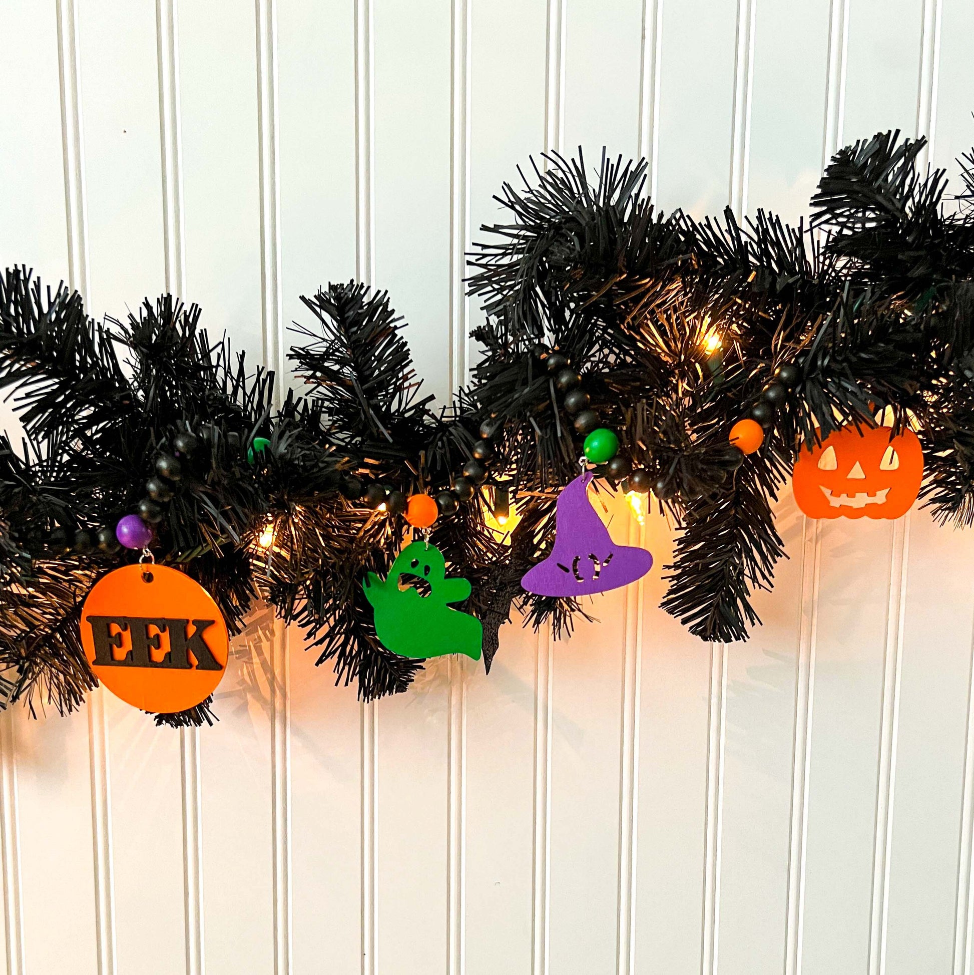 Eek! It’s Halloween Handmade Garland. The garland features seven Halloween themed shapes - pumpkins, ghosts, and witches’ hats. Shapes hang from painted wood beads. Halloween fall seasonal decoration or gift.