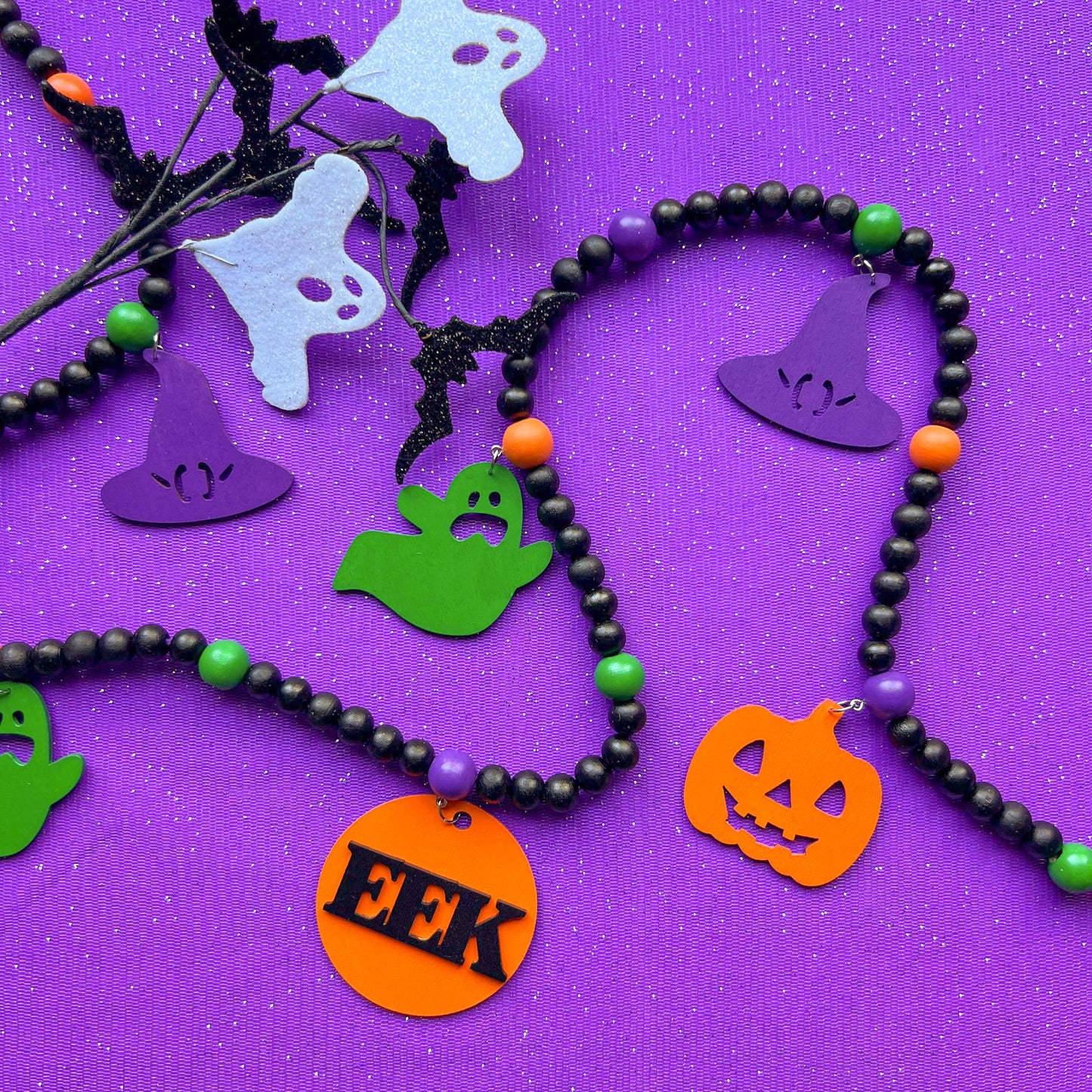 Eek! It’s Halloween Handmade Garland. The garland features seven Halloween themed shapes - pumpkins, ghosts, and witches’ hats. Shapes hang from painted wood beads. Halloween fall seasonal decoration or gift.