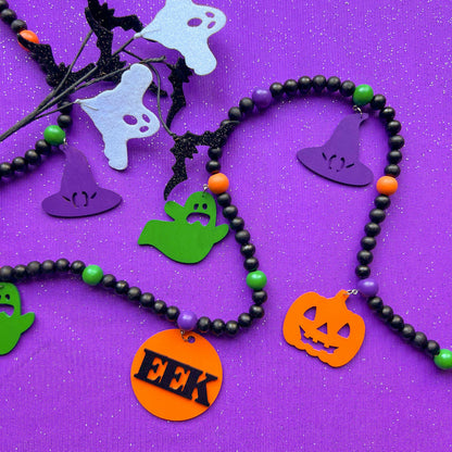 Eek! It’s Halloween Handmade Garland. The garland features seven Halloween themed shapes - pumpkins, ghosts, and witches’ hats. Shapes hang from painted wood beads. Halloween fall seasonal decoration or gift.