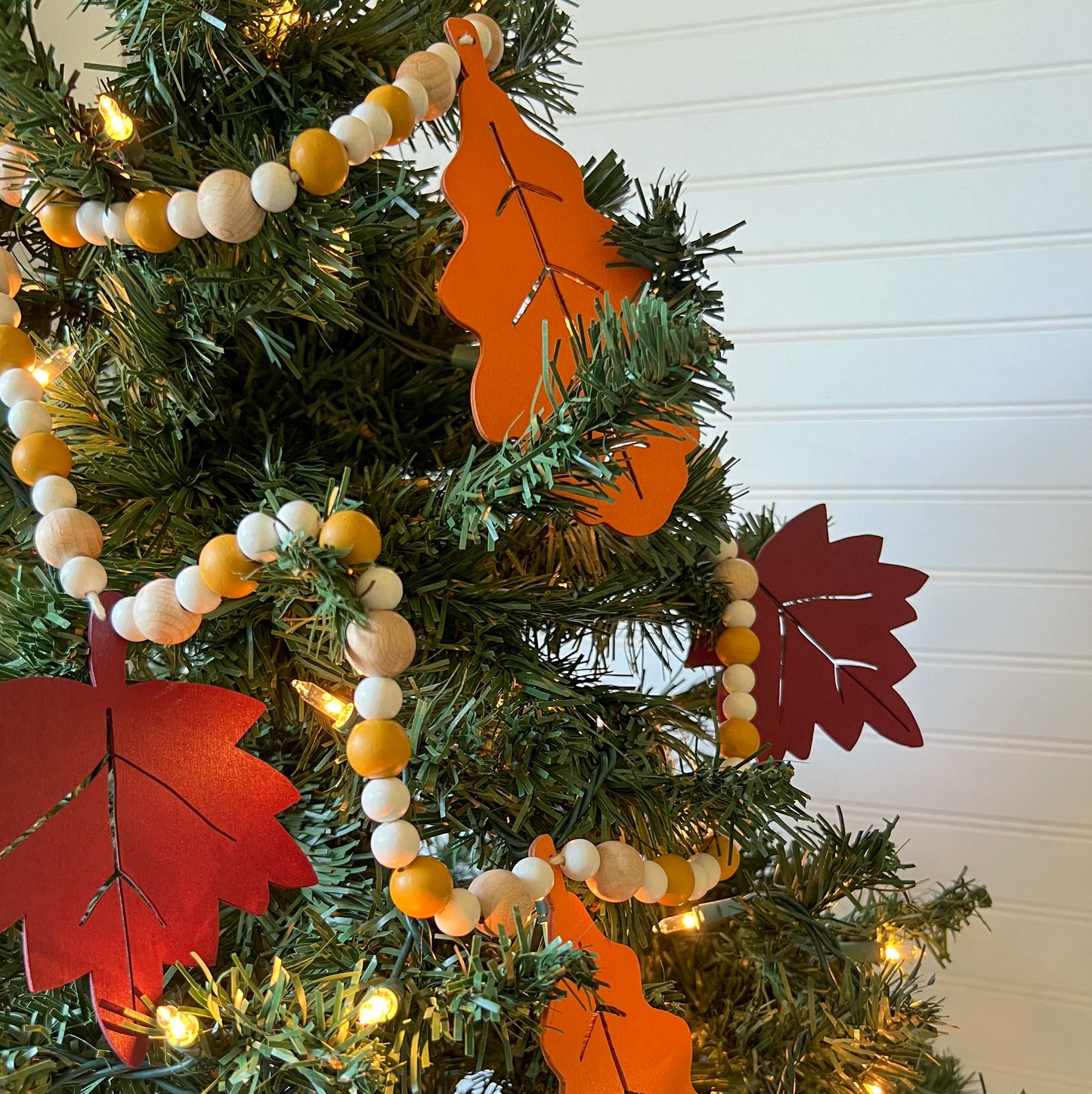 Fall themed wood bead garland with two wood oak leaves and three maple leaves strung with beads. 