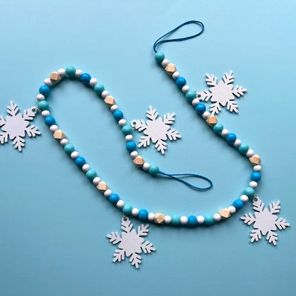 Falling Snowflakes Handmade Garland. The garland features five unique wood snowflakes that hang from painted wood beads. Christmas holiday winter seasonal decoration or gift.