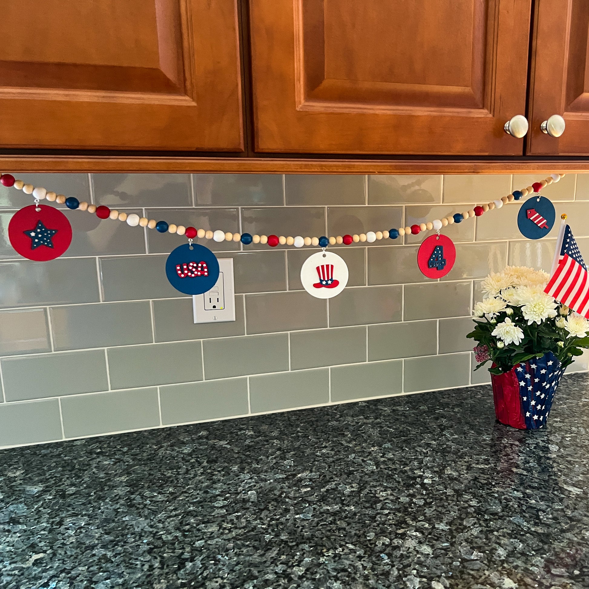 Happy 4th of July Handmade Garland. Features patriotic-themed shapes - a star, a "USA" and a 4th of July wood cutout, Uncle Sam's hat, and a firecracker. Summer red, white, blue decor and gifts.