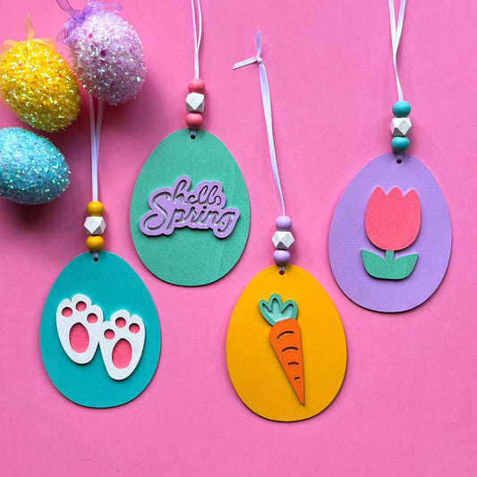 Hello Spring Handmade Ornaments. Flat egg shape ornaments with spring and Easter themed shapes - carrots, flower, rabbit paws. Spring decoration or gift.