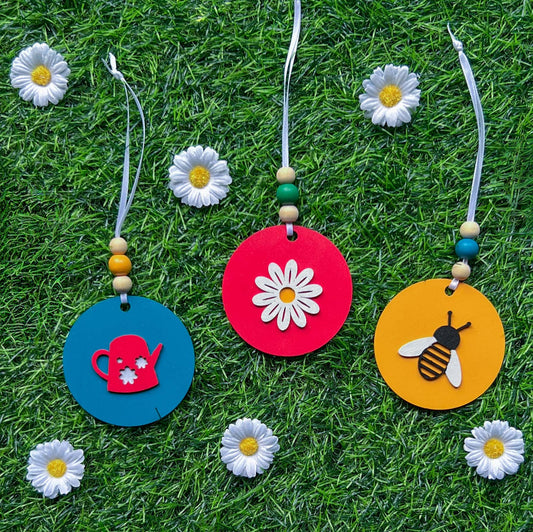 In the Garden Ornament Set. Three ornaments featuring a watering can, a daisy flower, and a bumblebee. Year-round holiday tree, spring decor or gift.